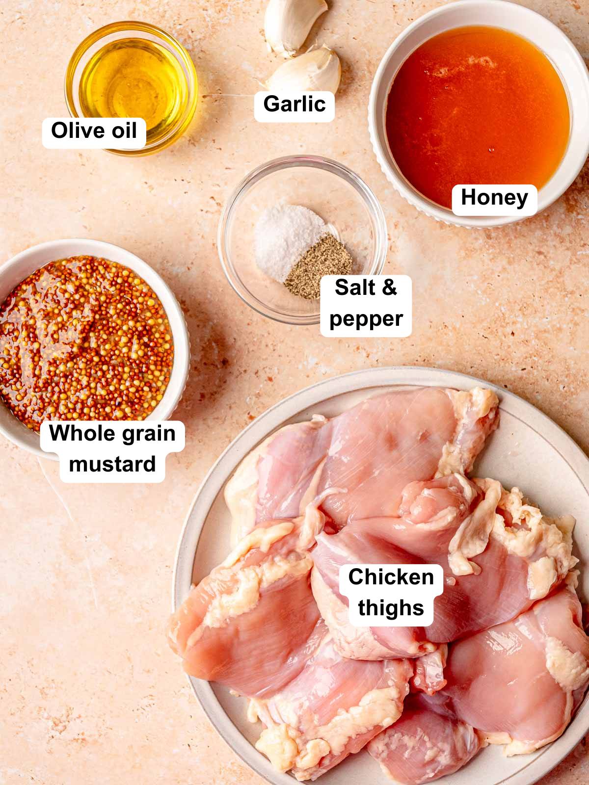 Labeled ingredients for honey mustard grilled chicken including chicken thighs, whole grain mustard, honey, garlic, olive oil, salt, and pepper.
