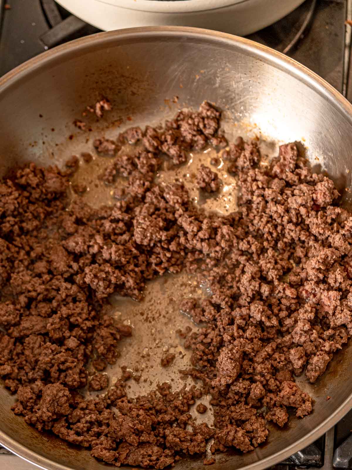 Ground beef browning in a skillet.