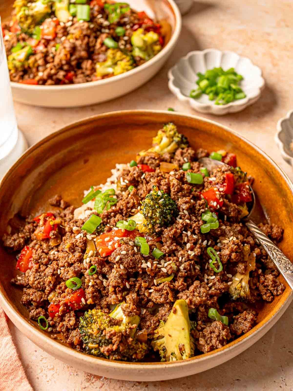 Quick beef stir fry bowl with scallions and sesame seeds.