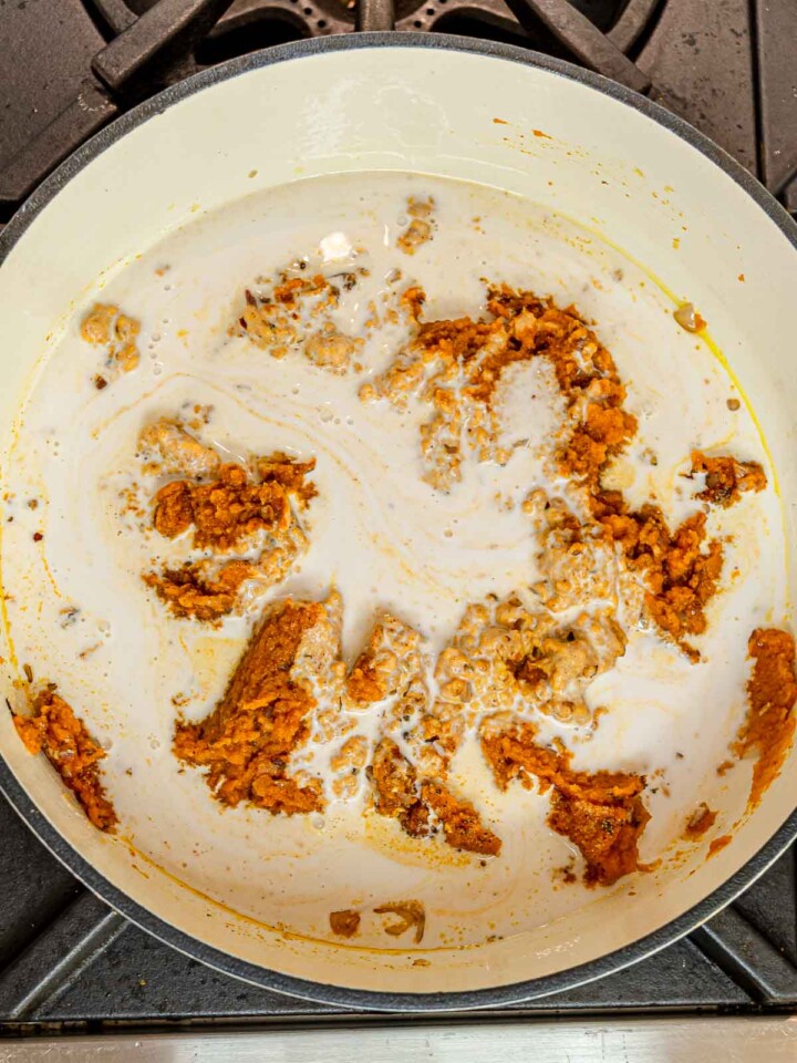 Pumpkin puree and spices combined with creamy coconut milk in a pot.