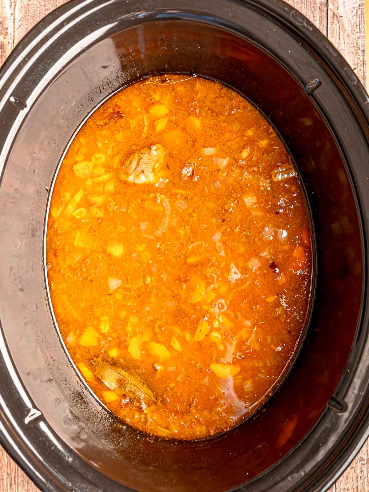 Beef and barley soup simmering in the slow cooker with rich broth and vegetables.
