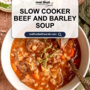 Text overlay reading “Slow Cooker Beef and Barley Soup” on a bowl of soup with beef, barley, and vegetables.