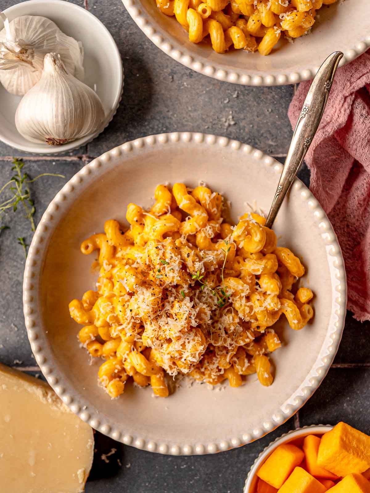 Close-up of creamy butternut squash mac and cheese with spoon in bowl.
