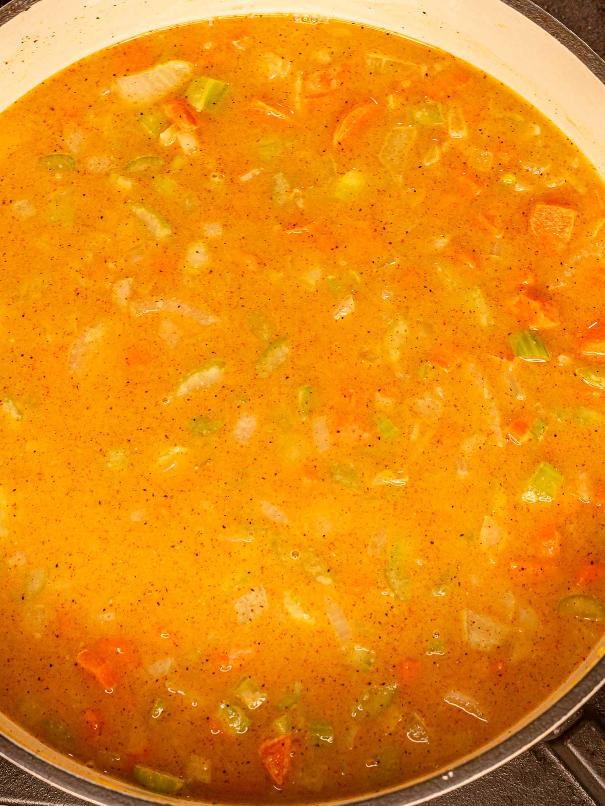 Broth and vegetables simmering together in a creamy sauce base.