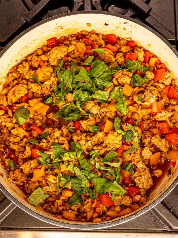 Stir fry with bell peppers, peanuts, and fresh basil and mint in the skillet.