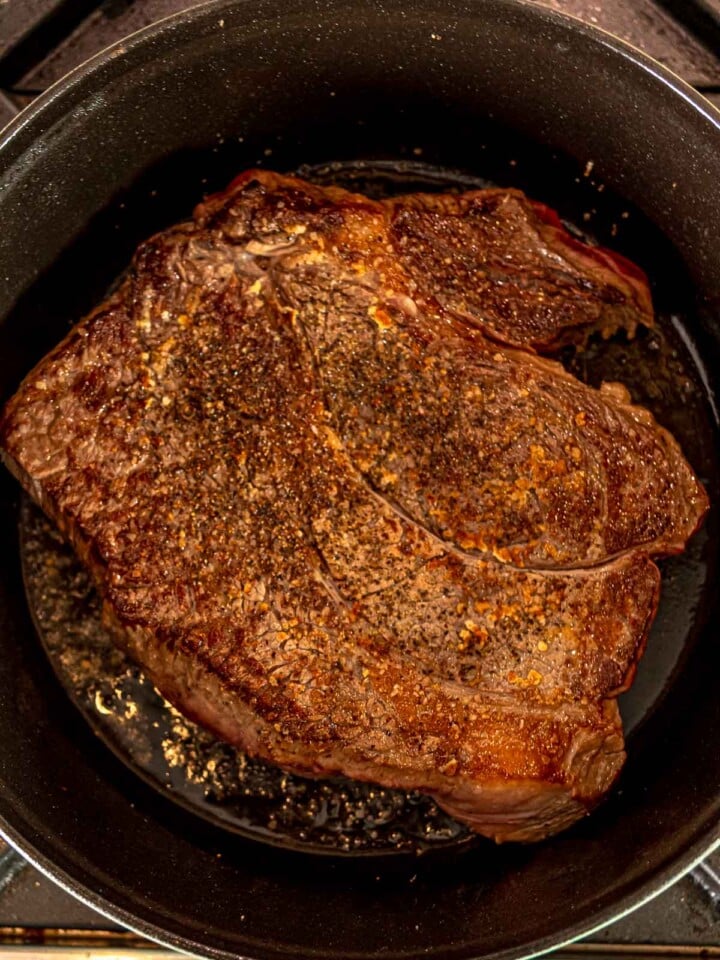 Well-browned chuck roast in a pan.