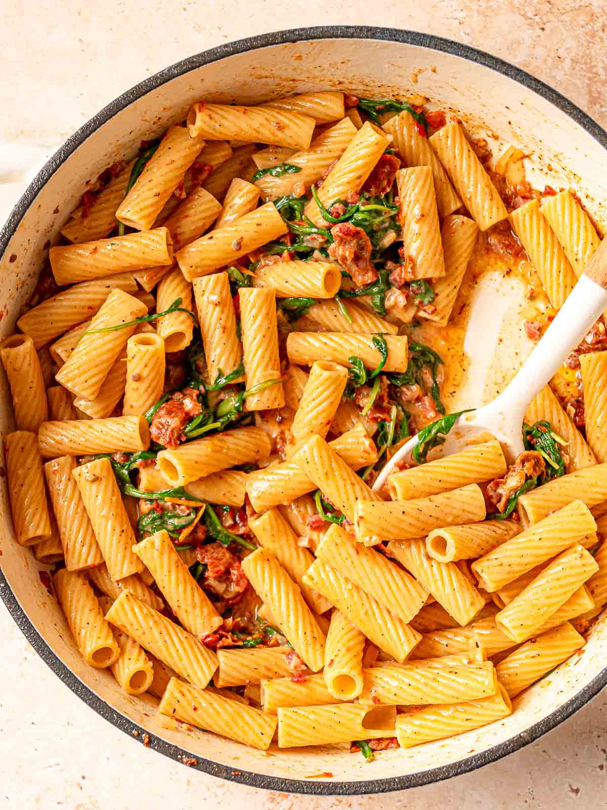 Rigatoni tossed in sun-dried tomato cream sauce with pancetta and wilted greens.