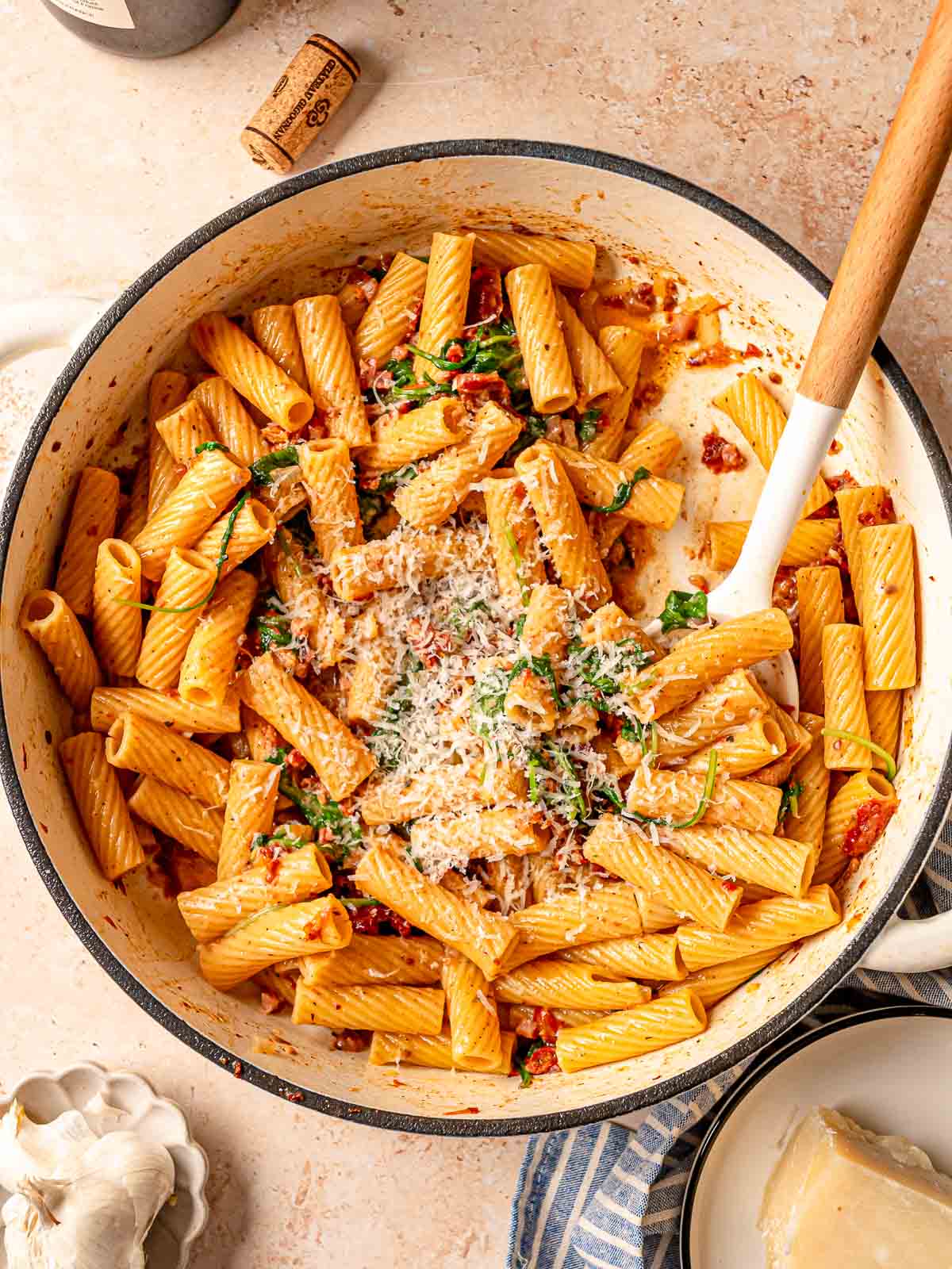 Large pot of sun-dried tomato rigatoni topped with grated Parmesan and herbs.