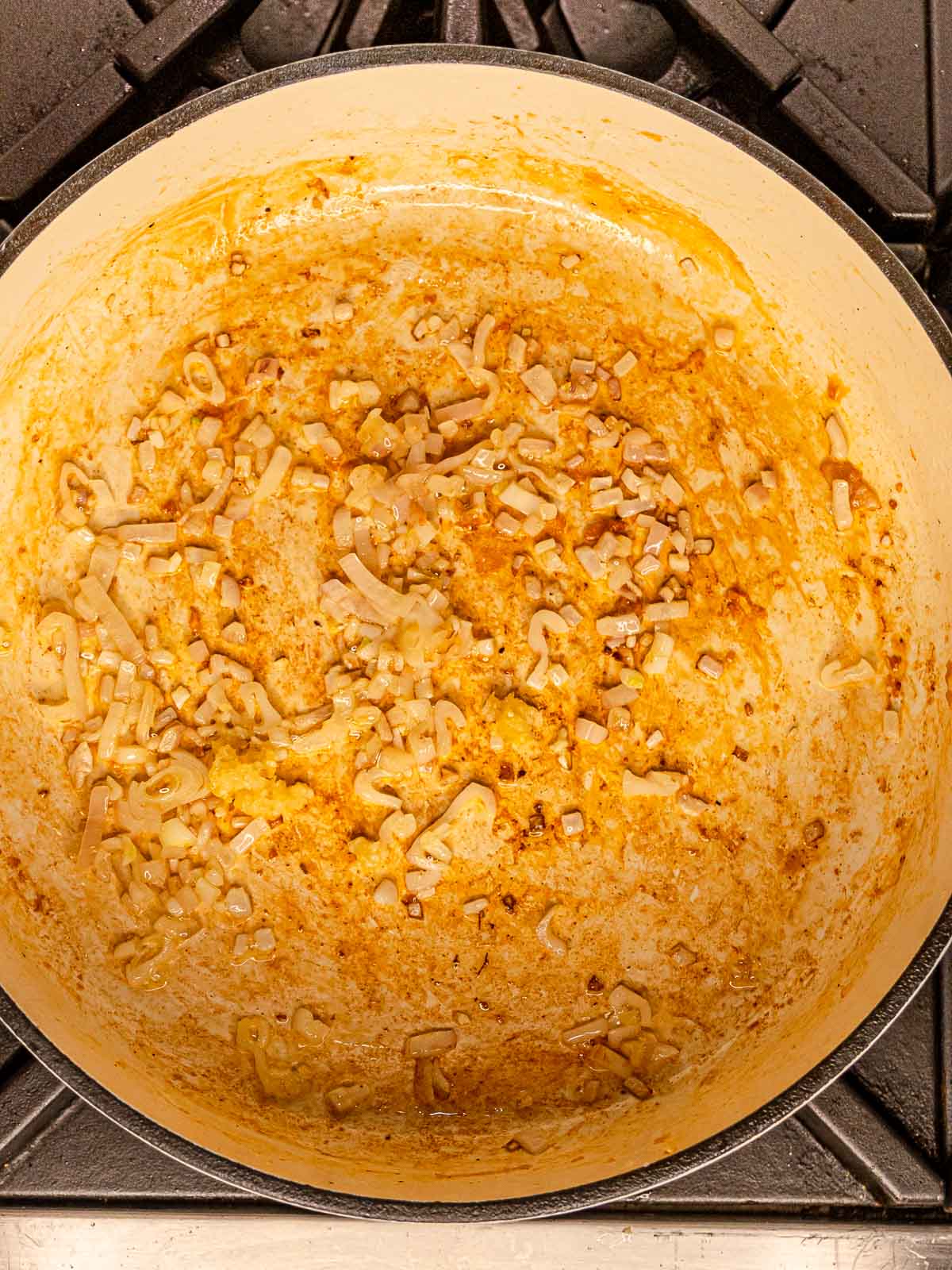 Minced shallots sautéing in a pot.