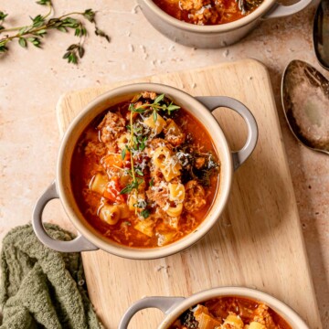 Cowl of Italian sausage kale soup filled with ditalini pasta, wilted kale, sausage, and shaved Parmesan.