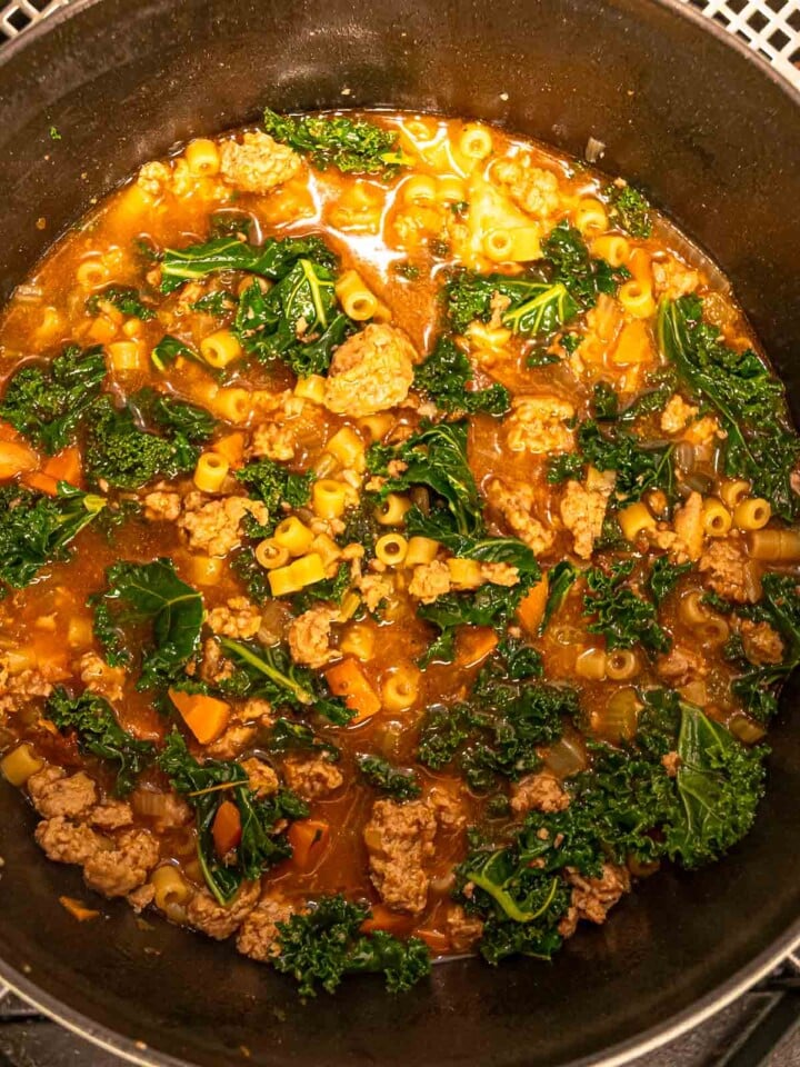 Italian sausage kale soup simmering with ditalini.