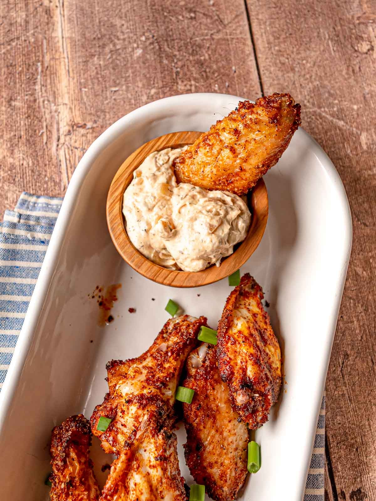 Baked chicken wings served with a creamy dipping sauce on the side.