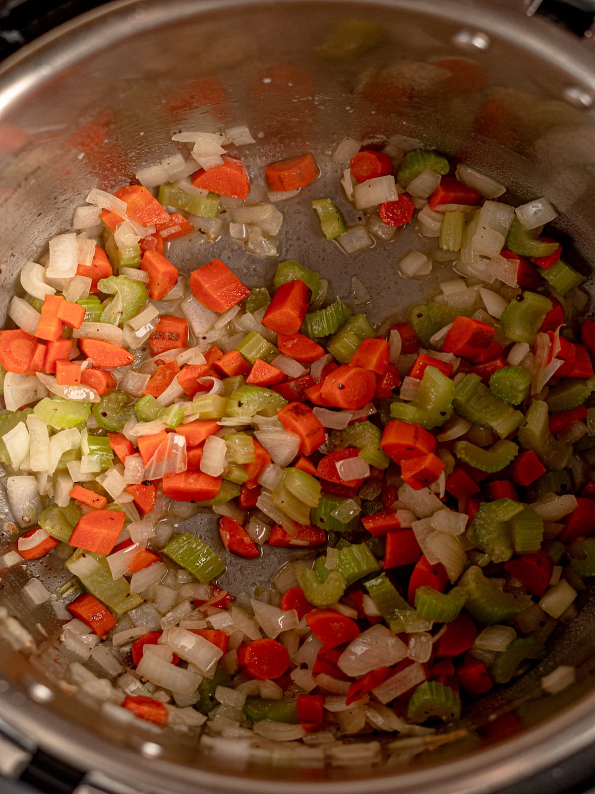 Mirepoix sautéing in a pan.