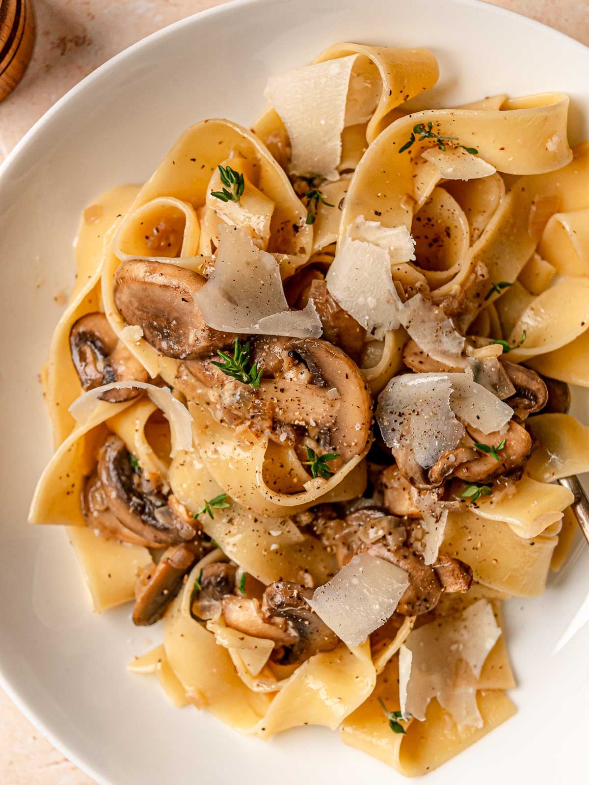 Close view of creamy mushroom pasta with wide noodles and sautéed mushrooms.