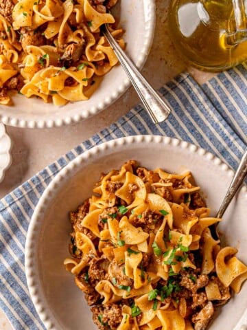 Ground beef stroganoff served in a bowl with egg noodles and fresh parsley.