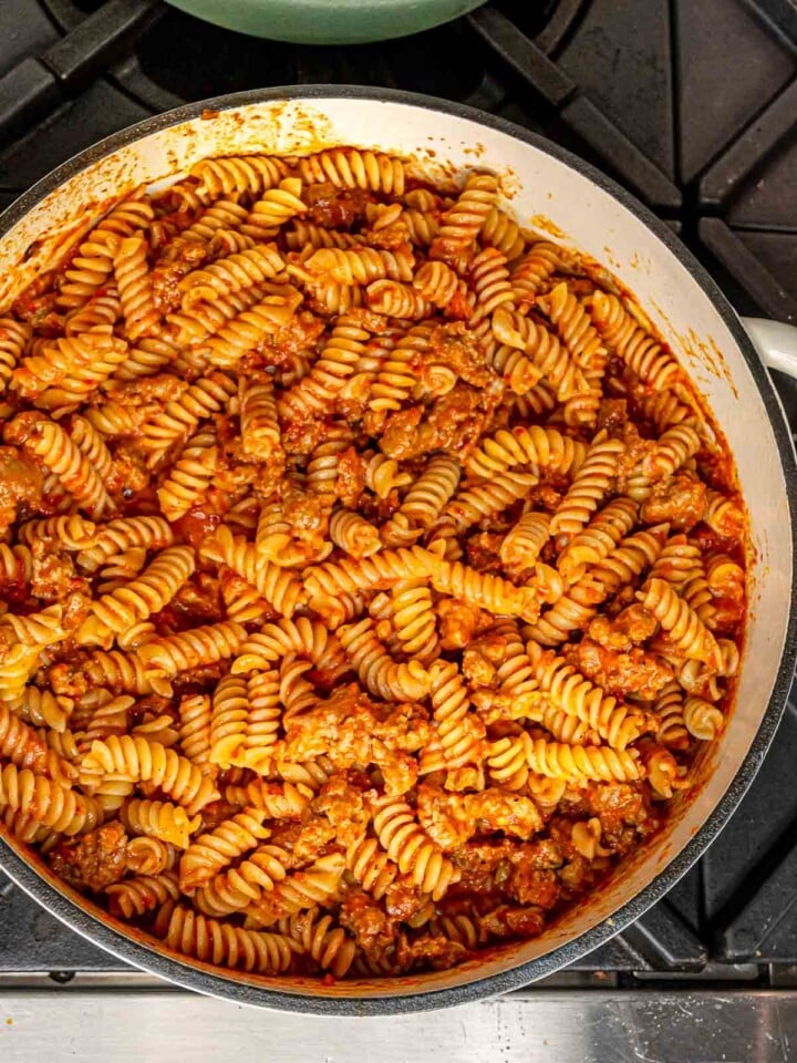 Short pasta tossed with the roasted red pepper sauce and sausage in the pan.