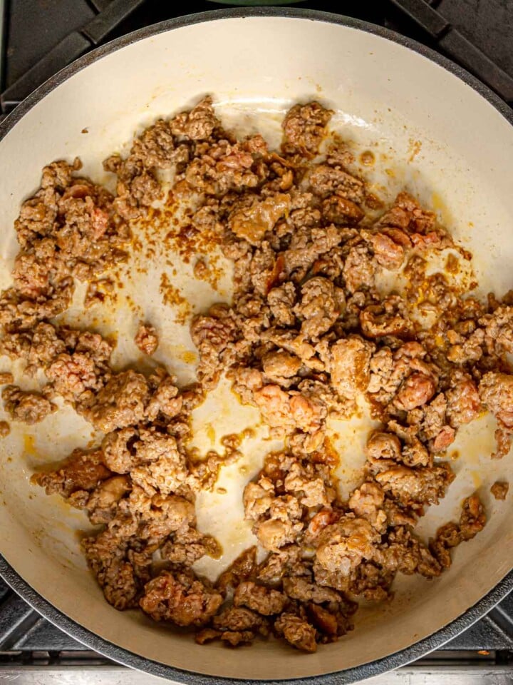 Italian sausage browned in a wide skillet until cooked through.