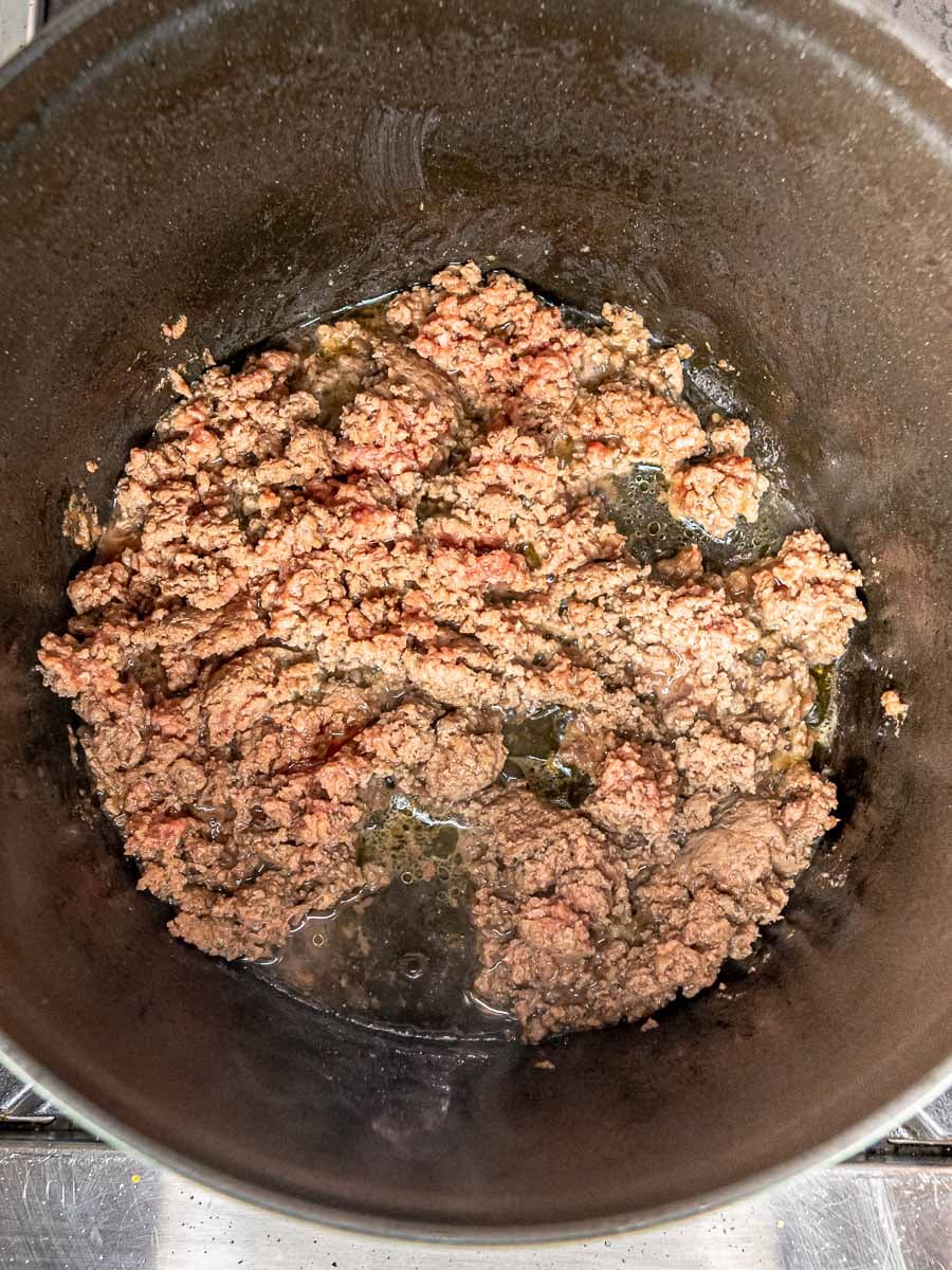 Browned ground beef crumbled in a large skillet.