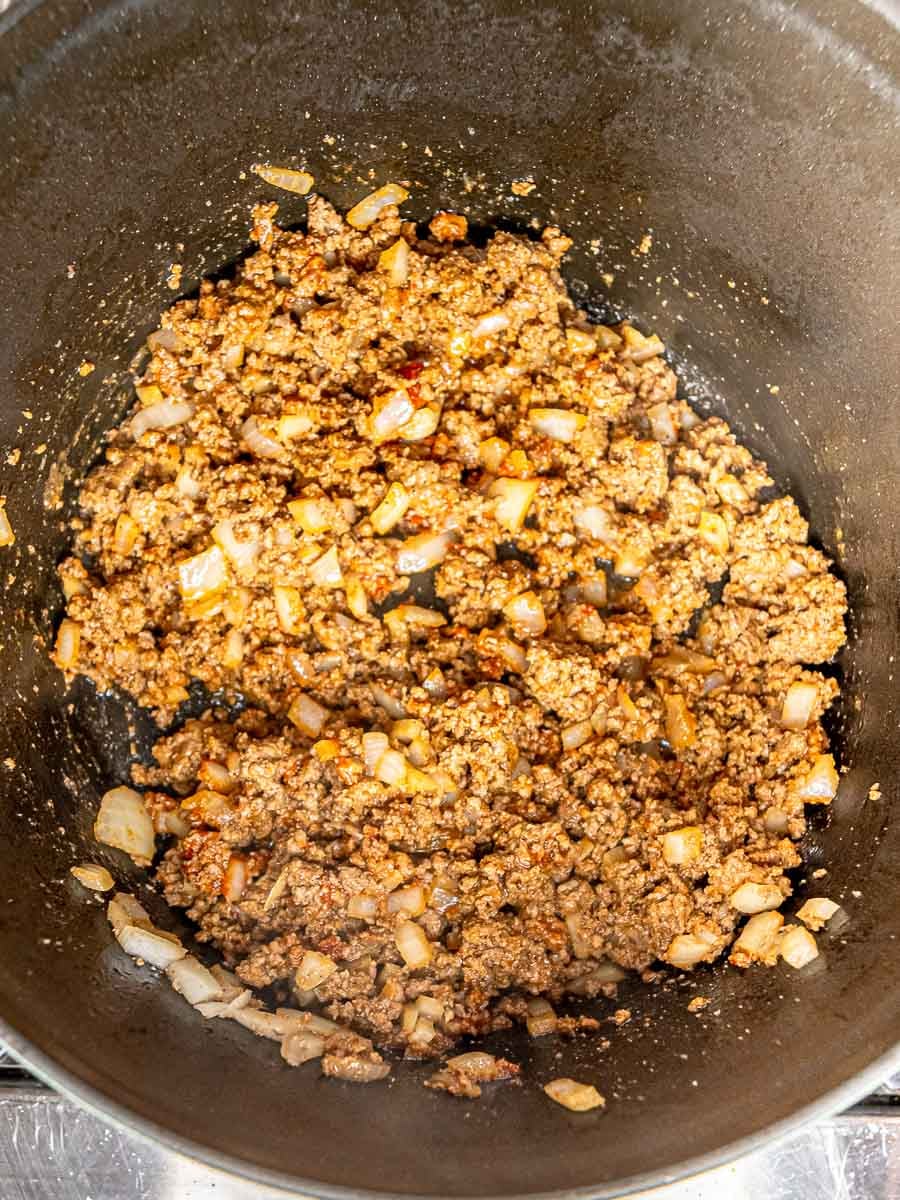 Ground beef mixture coated in seasonings and Worcestershire sauce in the skillet.