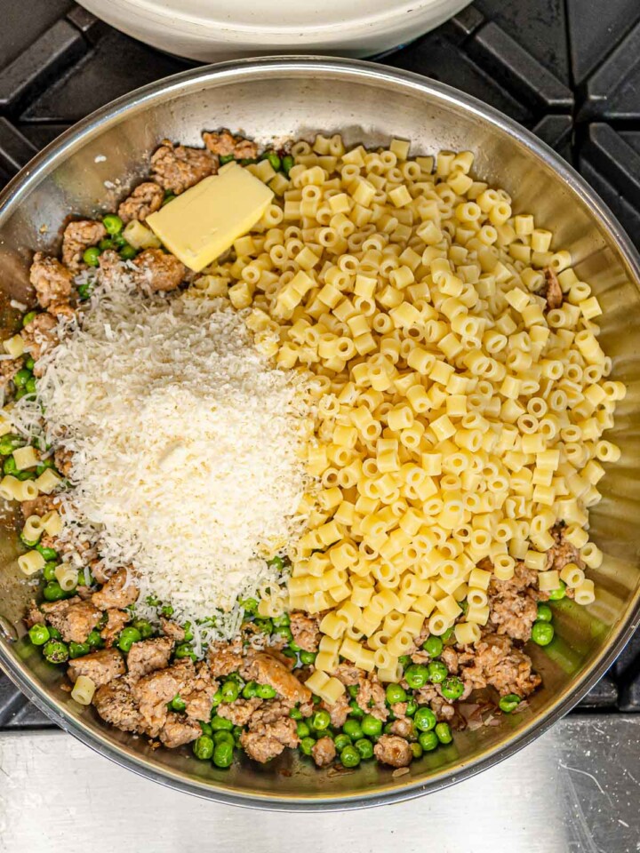 Cooked ditalini pasta, grated Parmesan cheese, and a pat of butter added to the skillet with the sausage and peas before tossing.