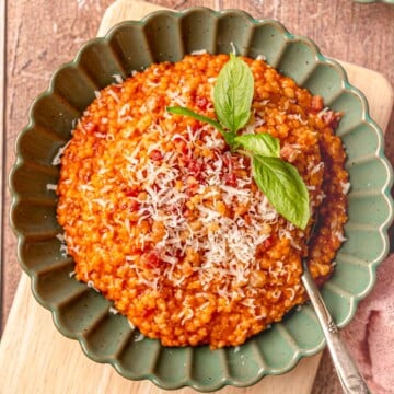 Tomato pastina with guanciale in a green scalloped-edge bowl.