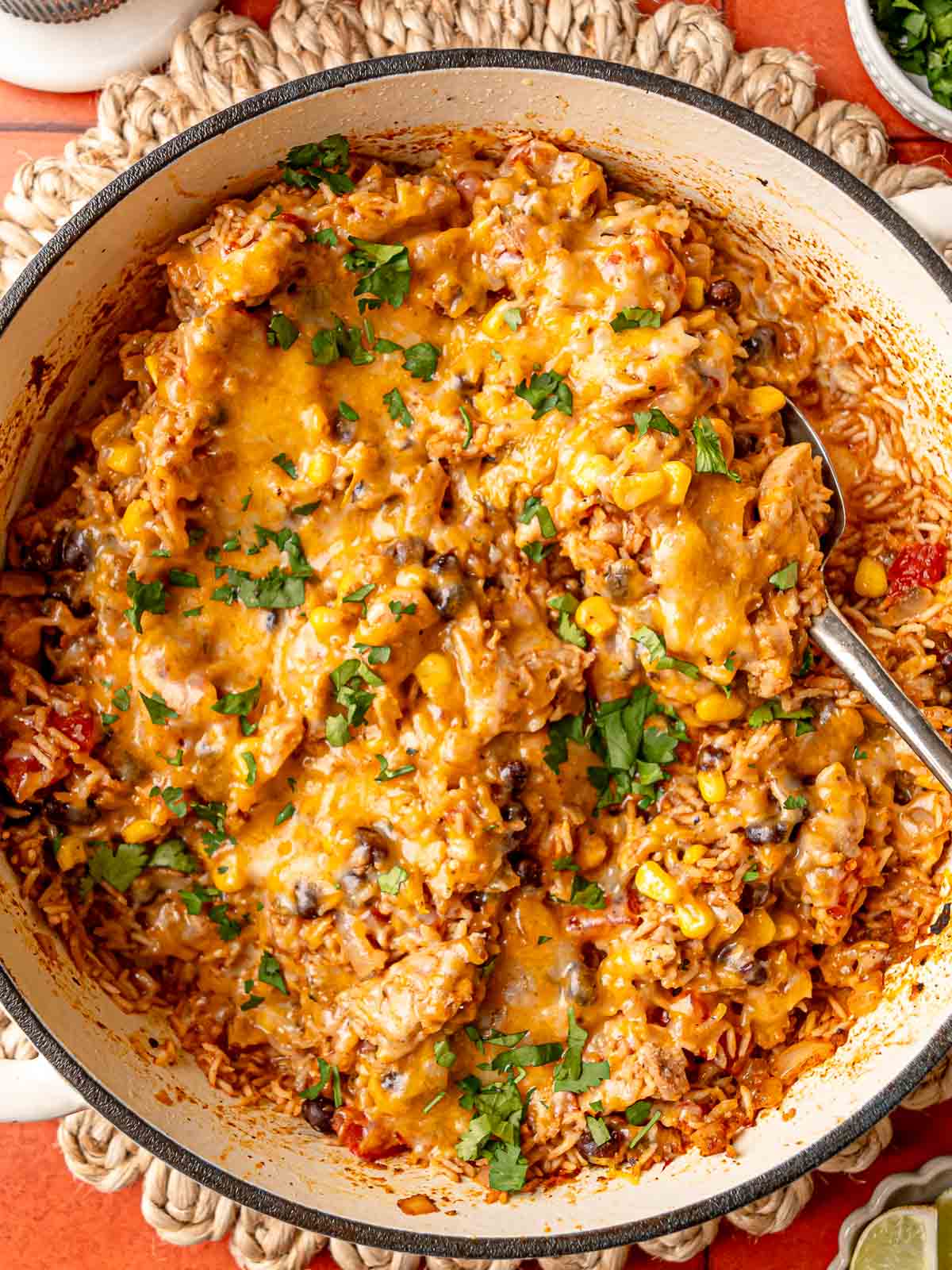 Tex-Mex chicken skillet with gooey melted cheese, visible corn and black beans, fresh cilantro.