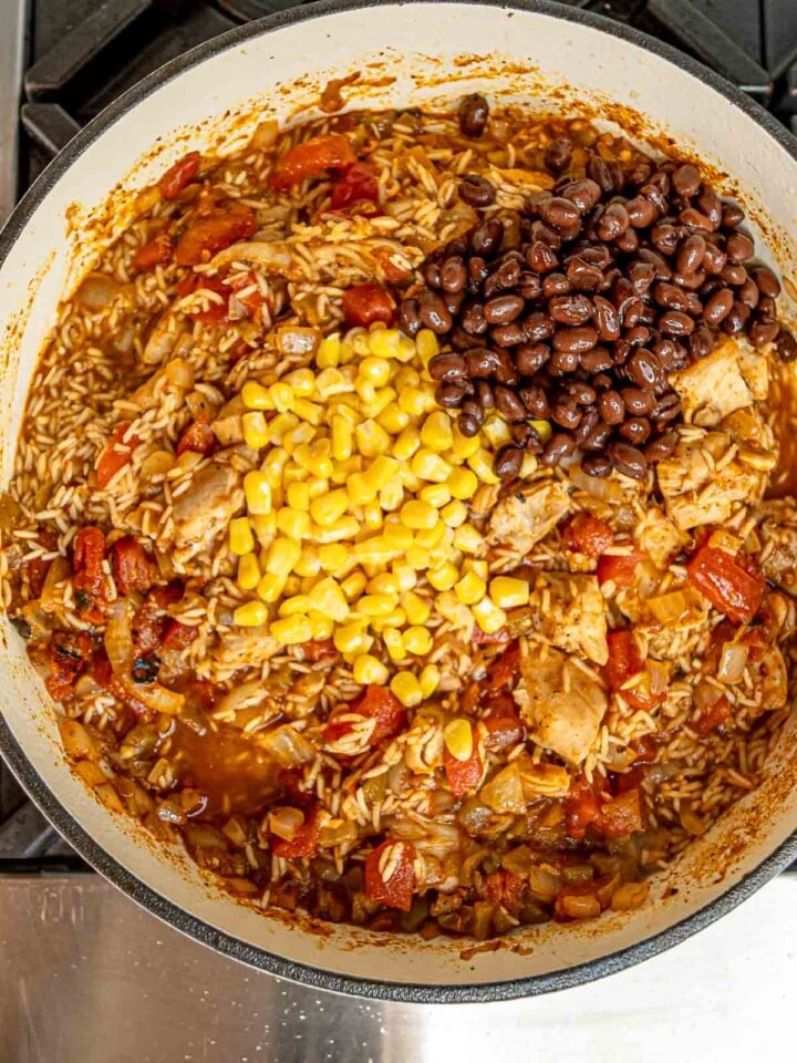 Rice, black beans, corn, and shredded chicken in tomato broth before adding cheese.