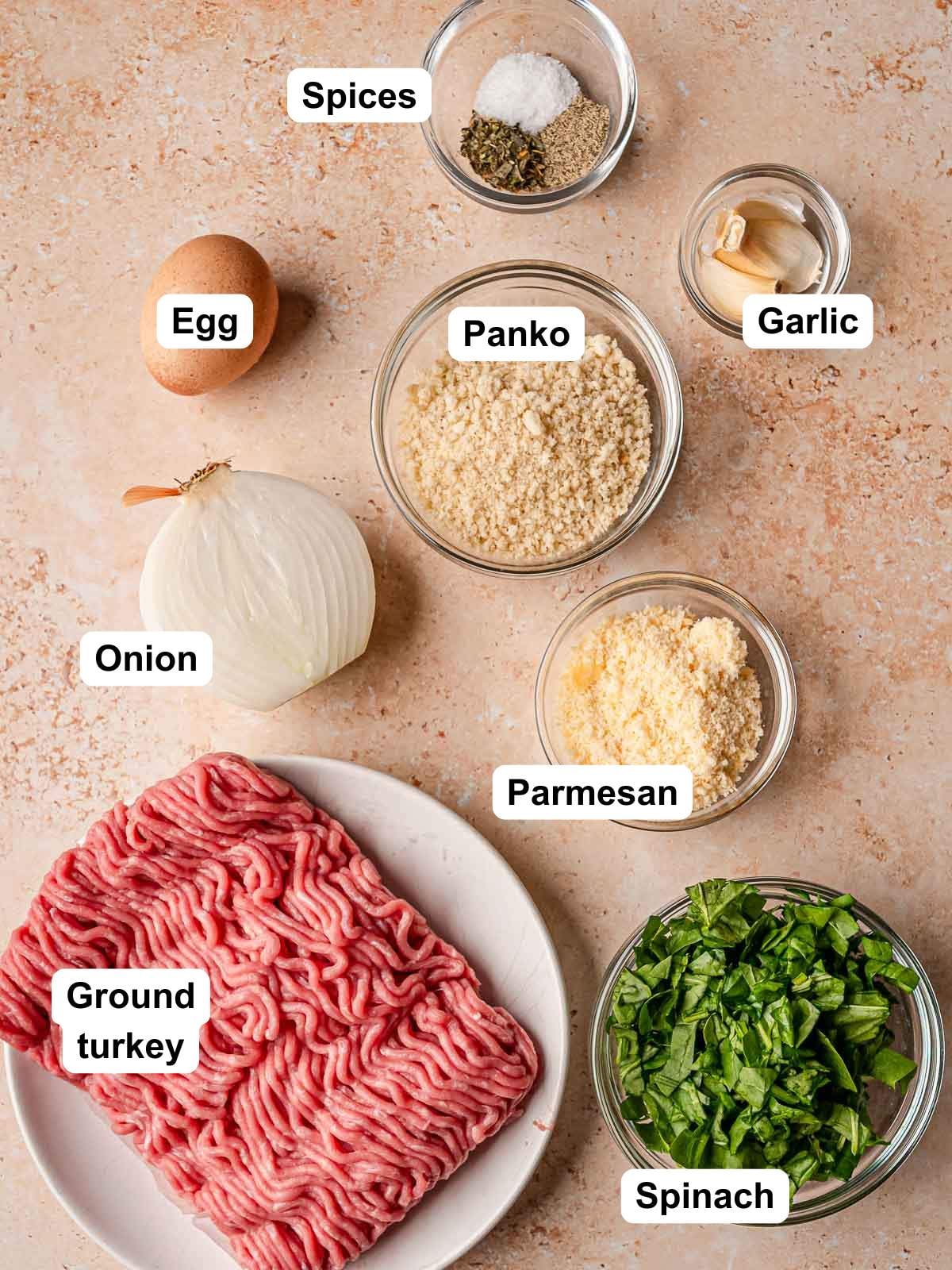 Ingredients for turkey spinach meatballs including ground turkey, chopped spinach, panko, parmesan, onion, egg, garlic, and spices.