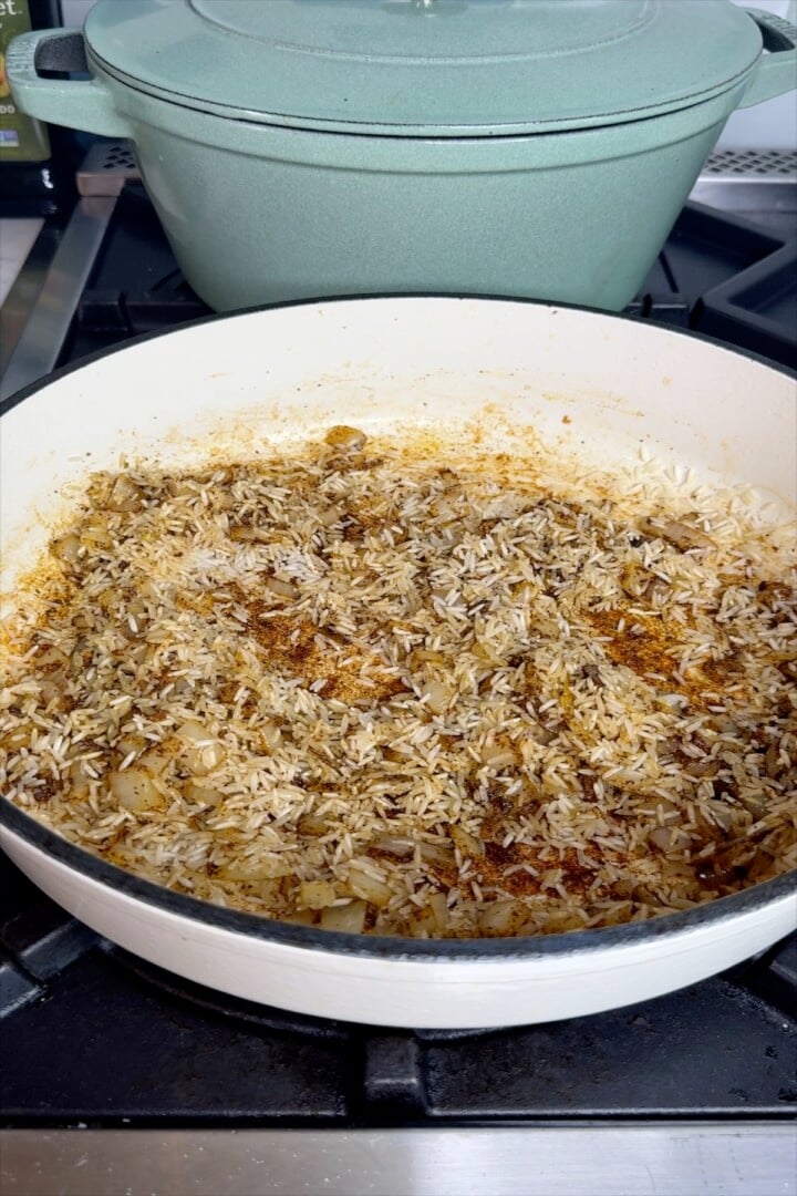 Onions, garlic and rice toasting in a skillet.