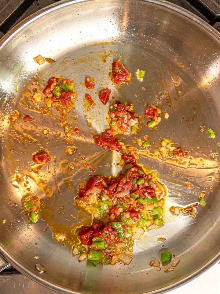 Tomato paste stirred into sautéed shallots, garlic, and pepper.
