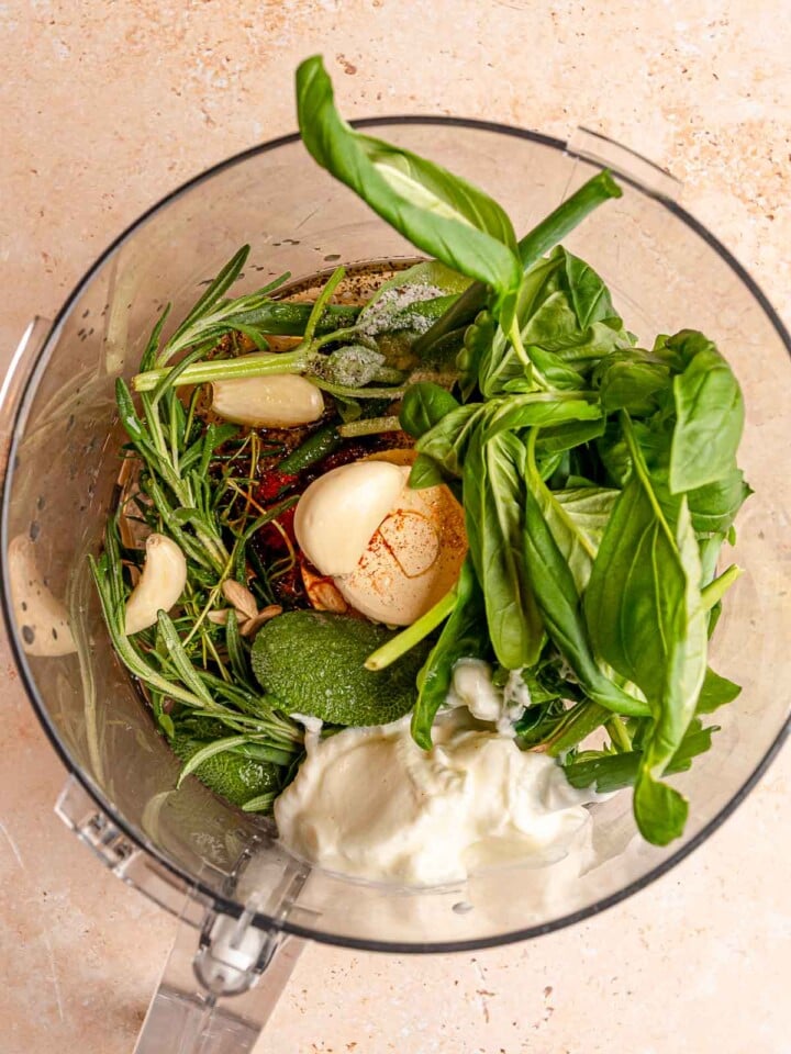 Fresh herbs, garlic, lemon, yogurt, olive oil and seasonings in a food processor for chicken marinade.