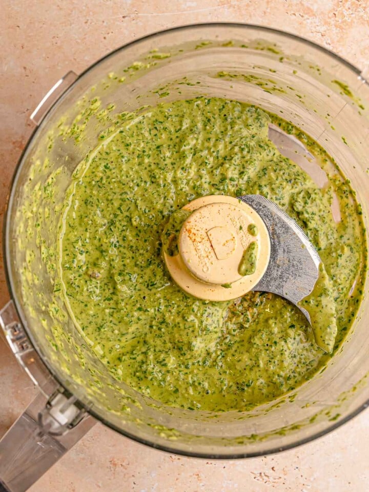 Creamy green herb marinade blended in a food processor.