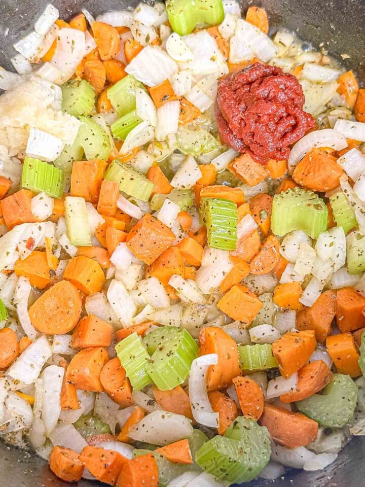 Tomato paste and garlic are added to sautéed carrots, celery, and onion for the pasta e fagioli base.