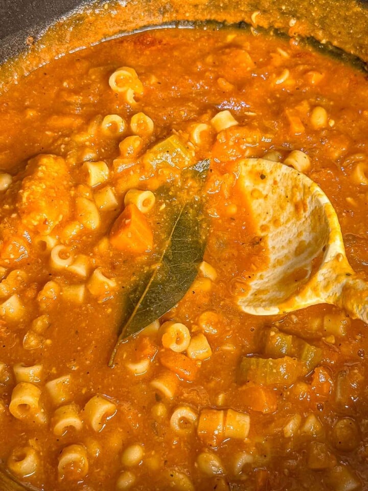 Ditalini pasta, cannellini beans, and vegetables simmer in a thick tomato broth with a bay leaf.