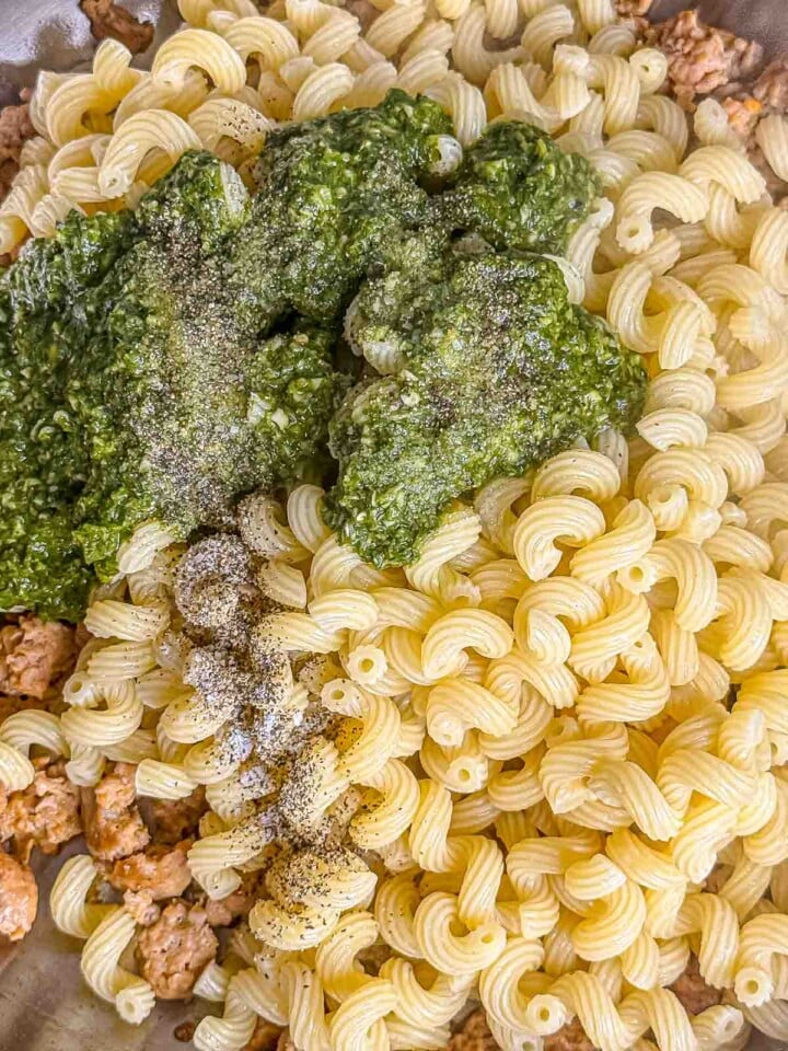 Cooked pasta, pesto, seasonings and browned Italian sausage combined in a skillet.
