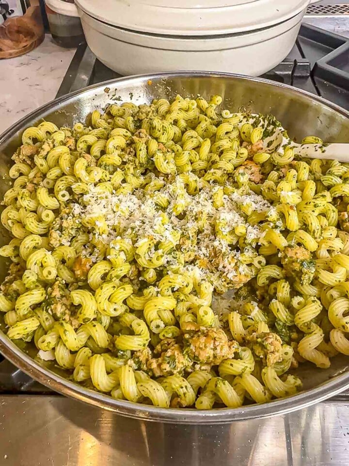 Pesto sausage pasta tossed together in a skillet and topped with freshly grated Parmesan.