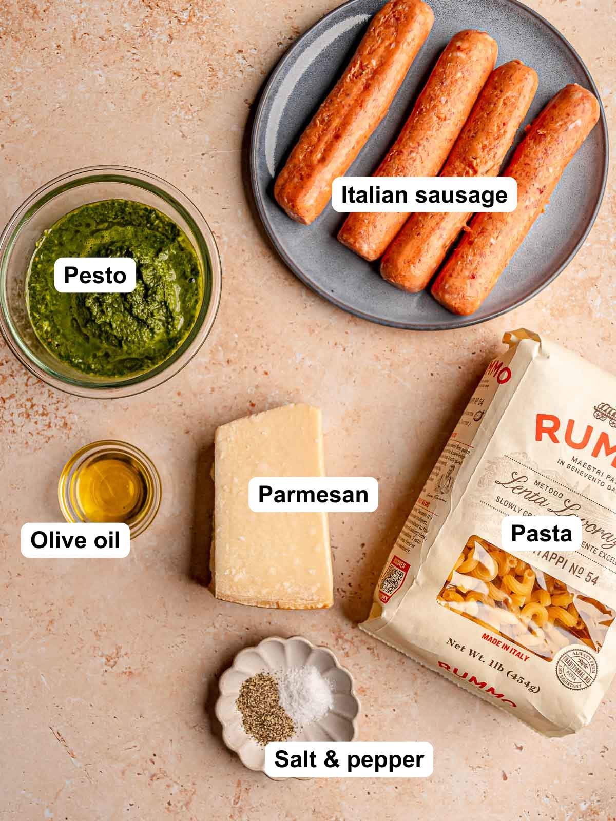 Ingredients for pesto sausage pasta: Italian sausage, pesto, pasta, Parmesan, olive oil, salt and pepper.